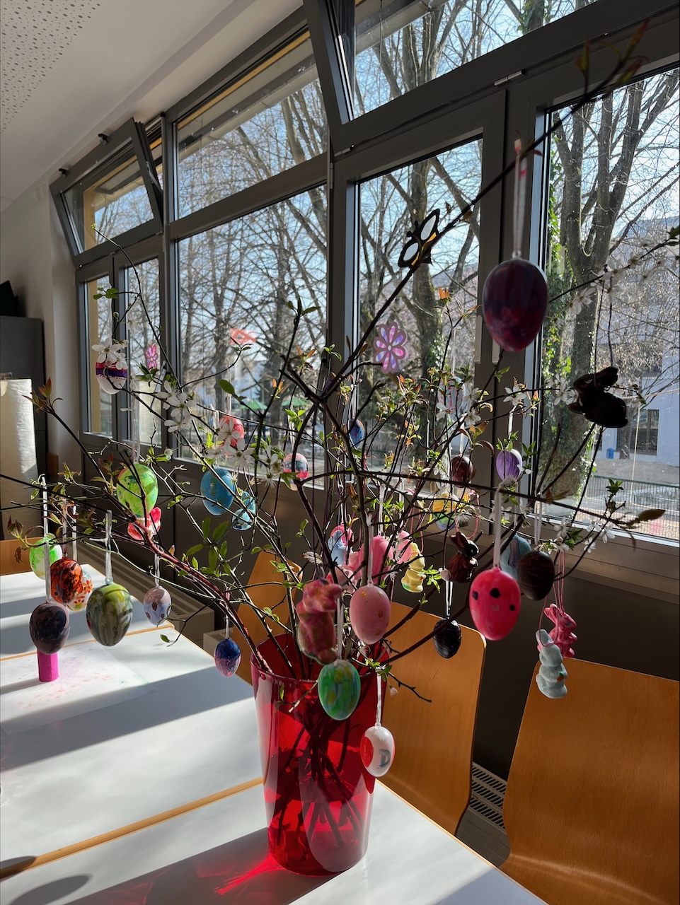 Osterstrauß mit bunt bemalten Eiern am Fenster des Freizeithauses