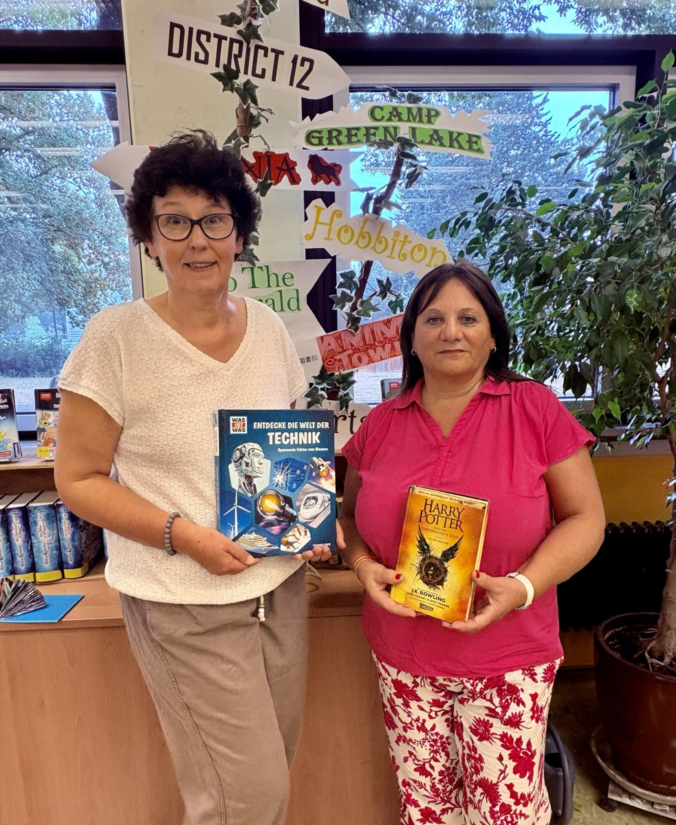 Die beiden Mitarbeiterinnen der Ausleihe mit Büchern in der Schulbücherei